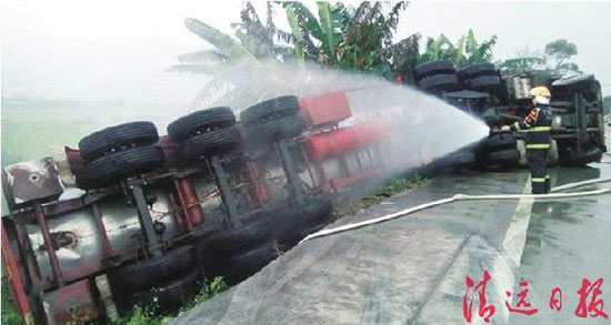 5月3日,一輛化學(xué)液體運(yùn)輸車側(cè)翻英坑公路上,消防員用水槍對(duì)罐車罐體進(jìn)行冷卻稀釋?，F(xiàn)場(chǎng)目擊者供圖 